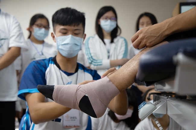長庚大學一日物理治療體驗營，物治系學生為高中生示範腳踝固定包紮。