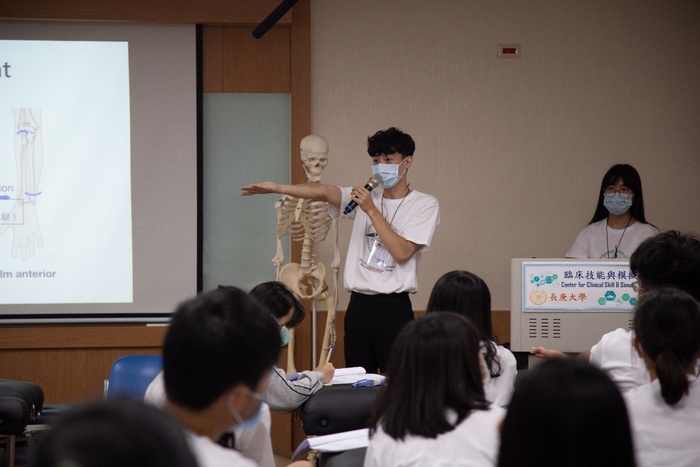 圖為物理治療系學生為高中生講解人體骨骼。