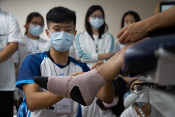 圖為物理治療系學生為高中生示範腳踝固定包紮。