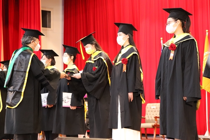 楊智偉副校長(左一)頒發畢業證書給碩士班畢業生代表。