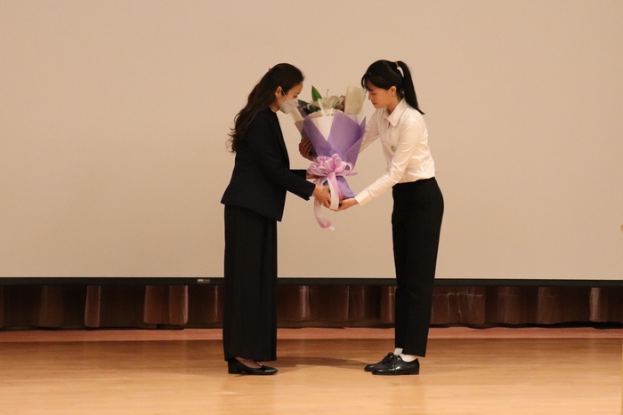 長庚大學羊珈伶同學(圖右)代表受教學生獻花給李銘哲大體老師之女李怡禛女士(圖左)。